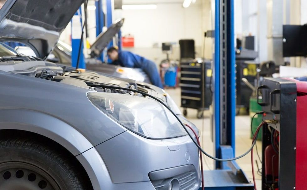 A Car is Being Serviced in a Garage With the Hood Up — Queensland Roadworthy Services In Southport, QLD