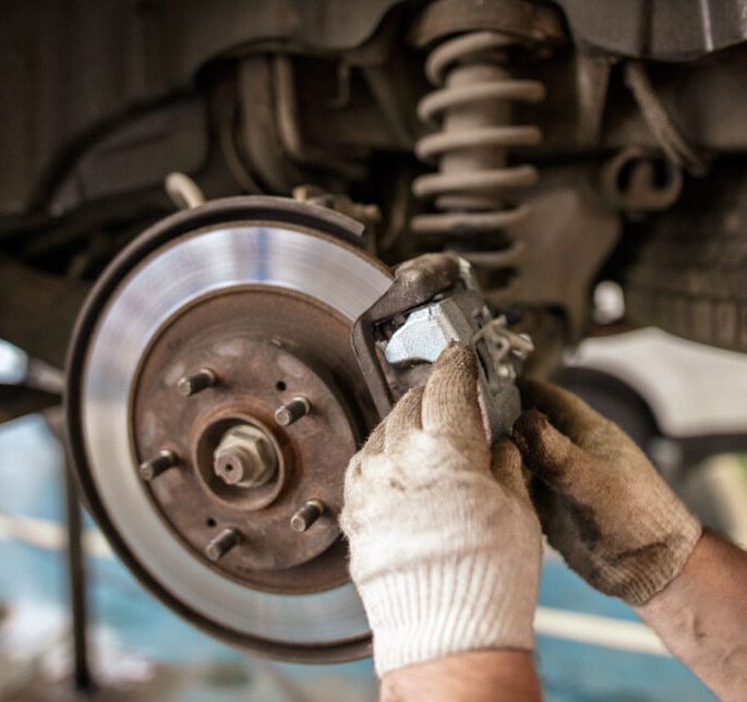 A Person is Working on the Brake Pads of a Car — Queensland Roadworthy Services In Southport, QLD
