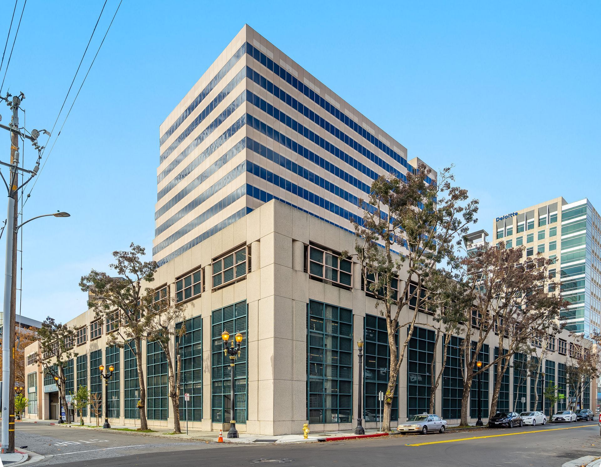 Two construction workers on a suspended platform cleaning exterior windows of a high-rise building.