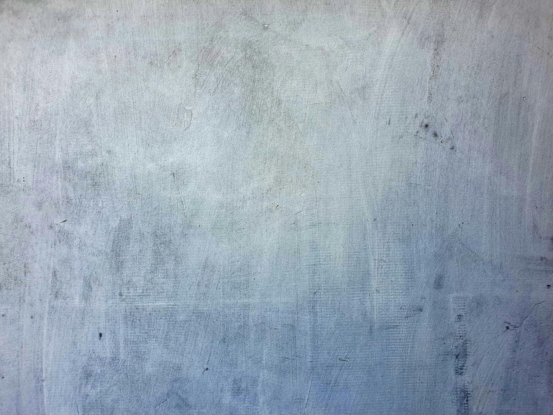 Textured gray-blue concrete wall, with subtle tonal variations and imperfections.