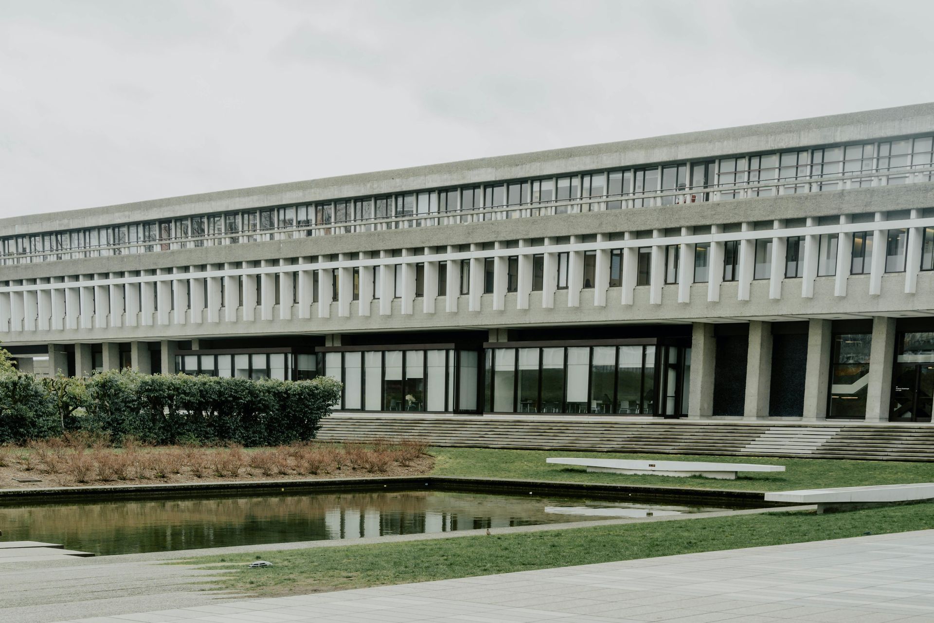 Exterior view of a long, concrete building with multiple windows.