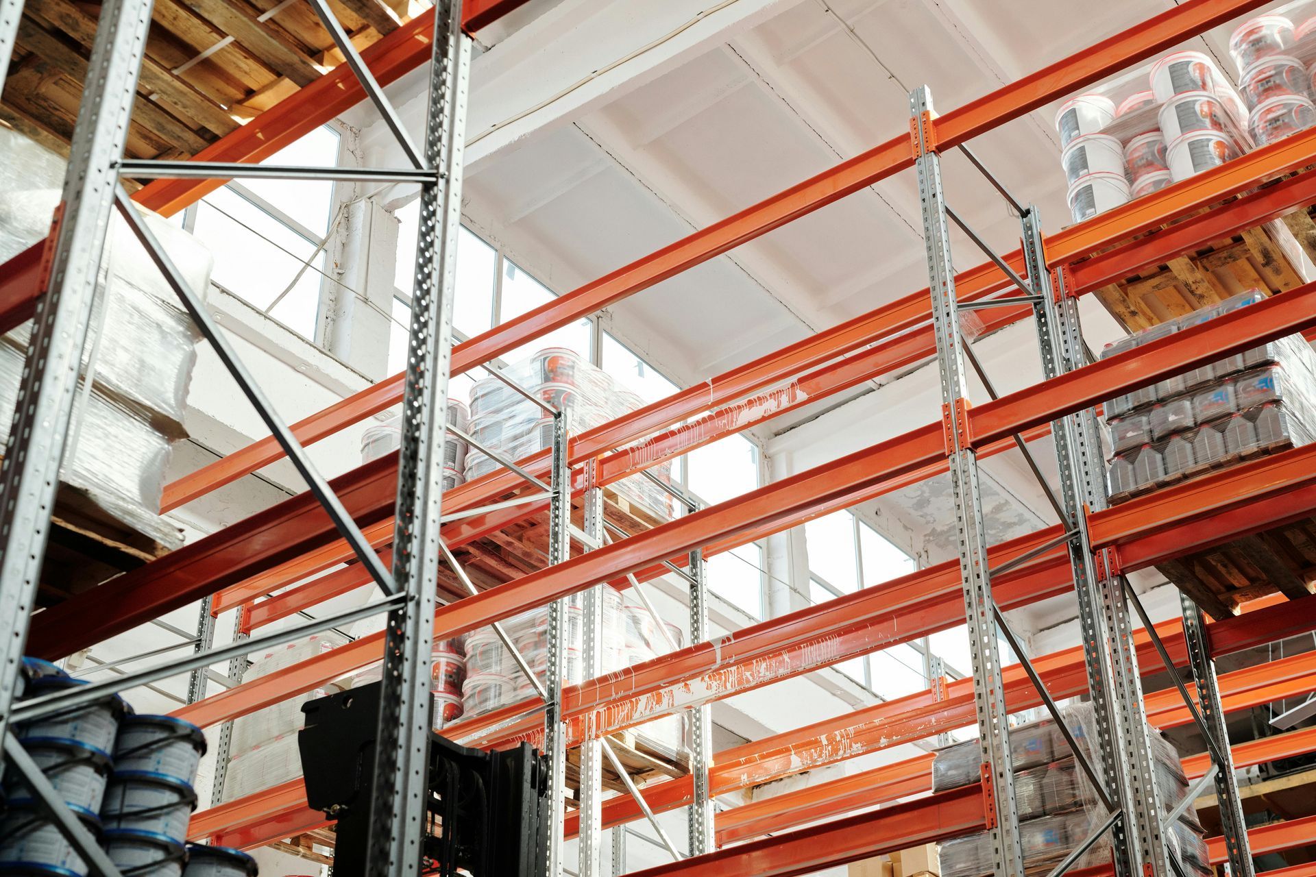 Warehouse shelving filled with products; orange beams, metal supports.