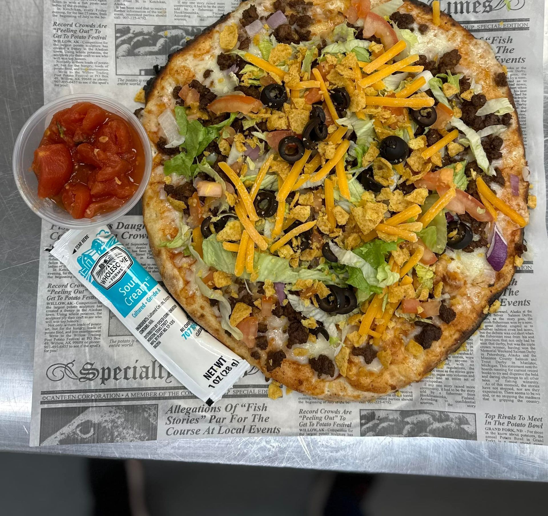 A close up of a pizza with tomatoes , basil , olives and cheese.