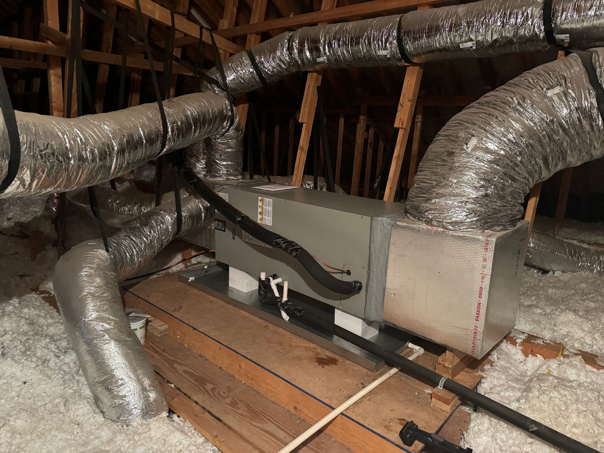 A bunch of pipes are hanging from the ceiling of a building.
