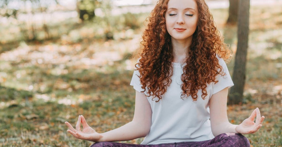 A woman is sitting on the floor with her head in her hands and a hand reaching out to help her