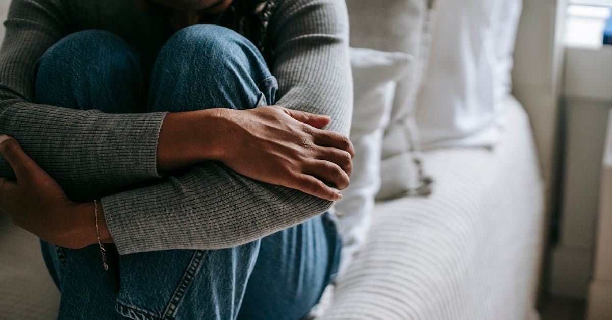 A woman is sitting on a couch with her legs crossed.