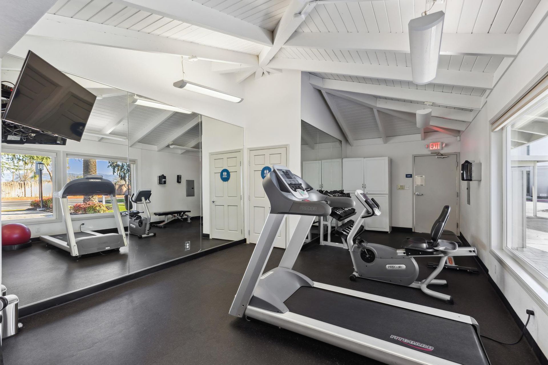 On-site fitness center with treadmill, stationary bike, mirrors and weights.
