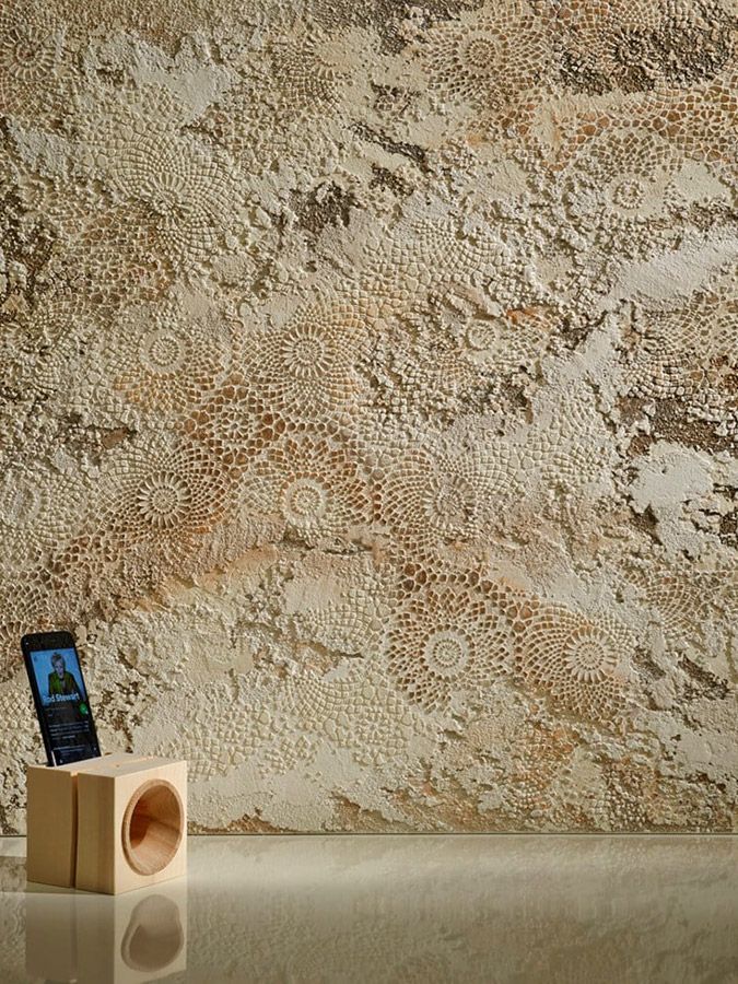 A cell phone is sitting on a wooden box in front of a wall.