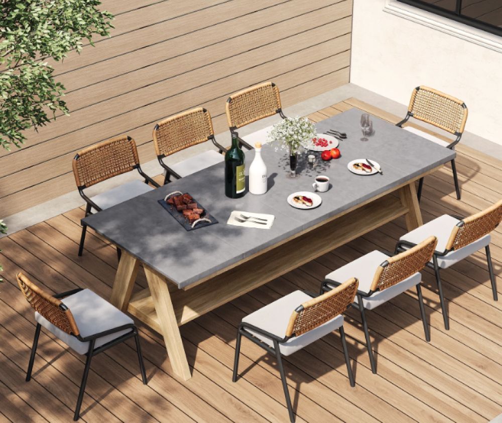 A table and chairs on a wooden deck with a bottle of wine on it.