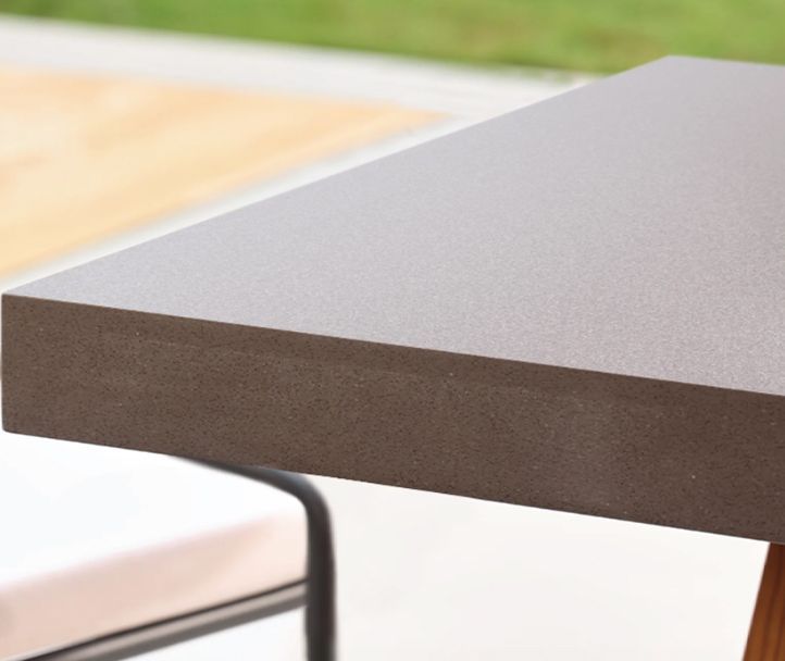 A table and chairs on a wooden deck with a bottle of wine on it.