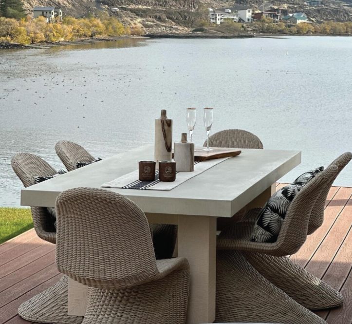 A table and chairs on a deck overlooking a lake