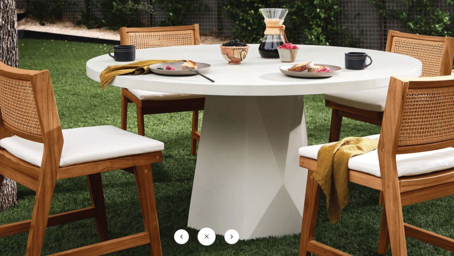 A table and chairs are sitting on top of a lush green lawn.