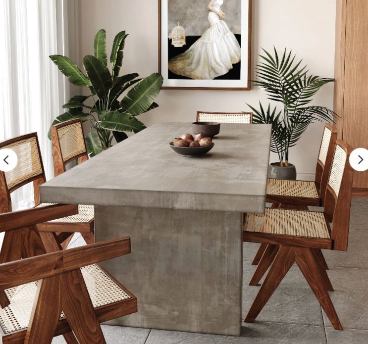 A dining room with a table and chairs and a picture on the wall