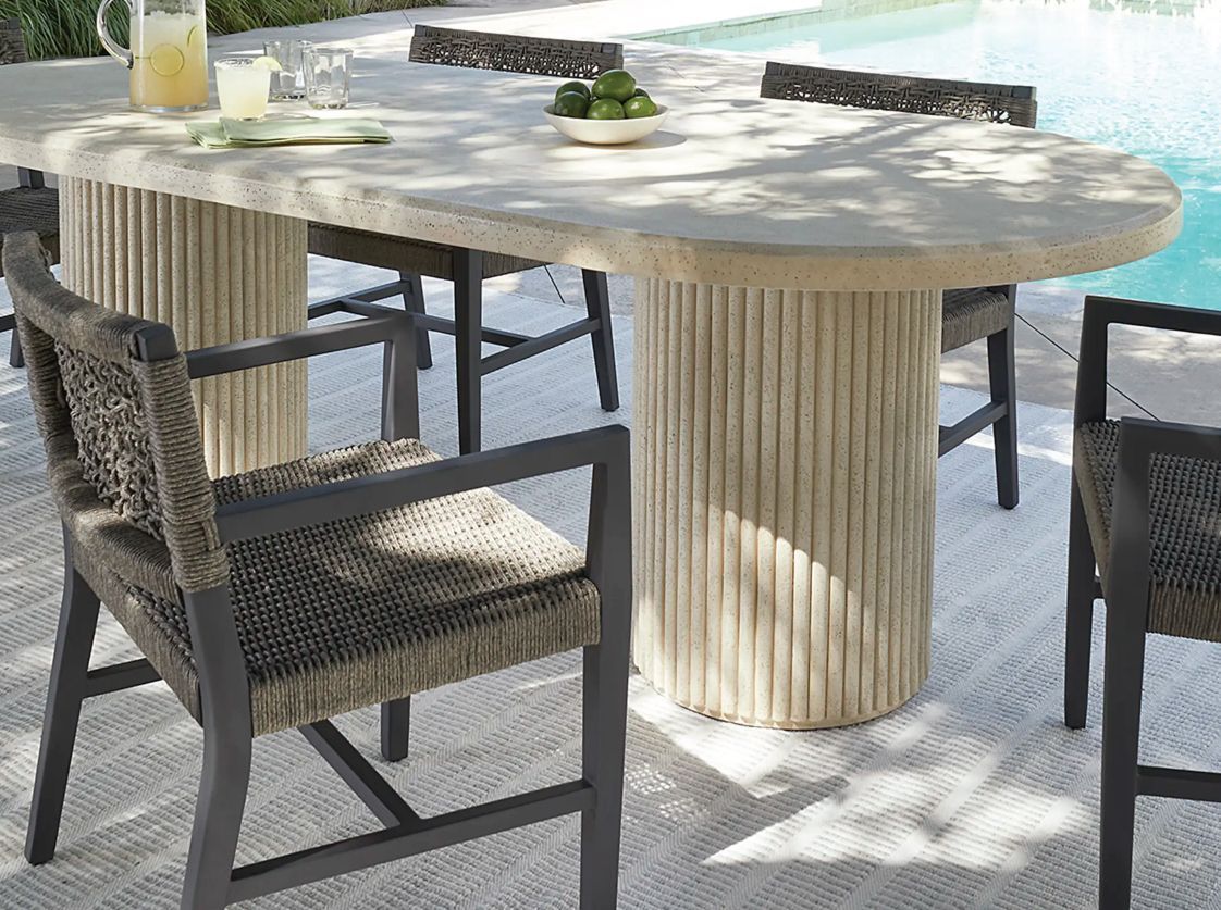 A table and chairs are sitting next to a pool.