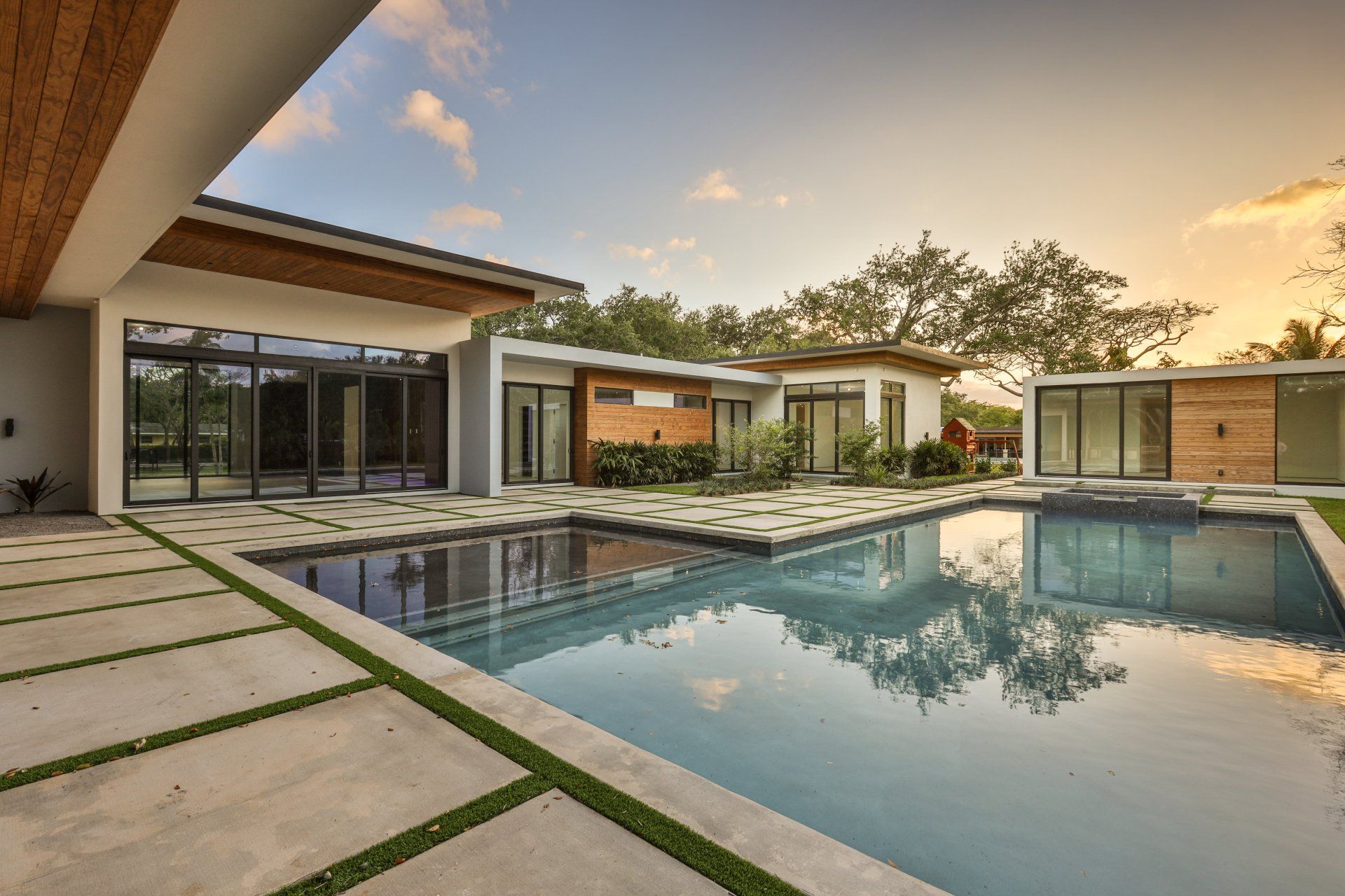 a modern house with a large swimming pool in front of it