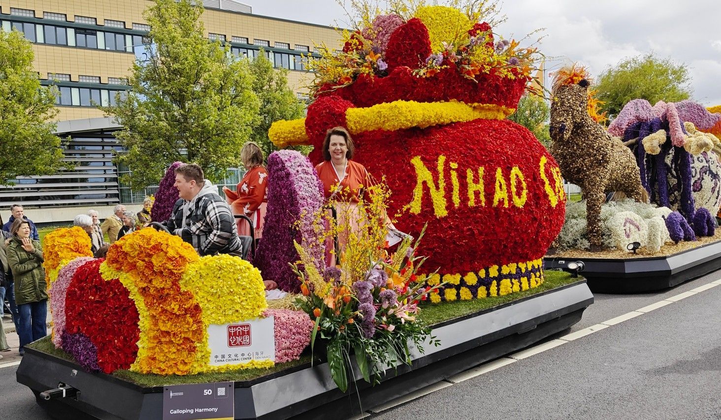 Een met bloemen bedekte praalwagen met de letters 