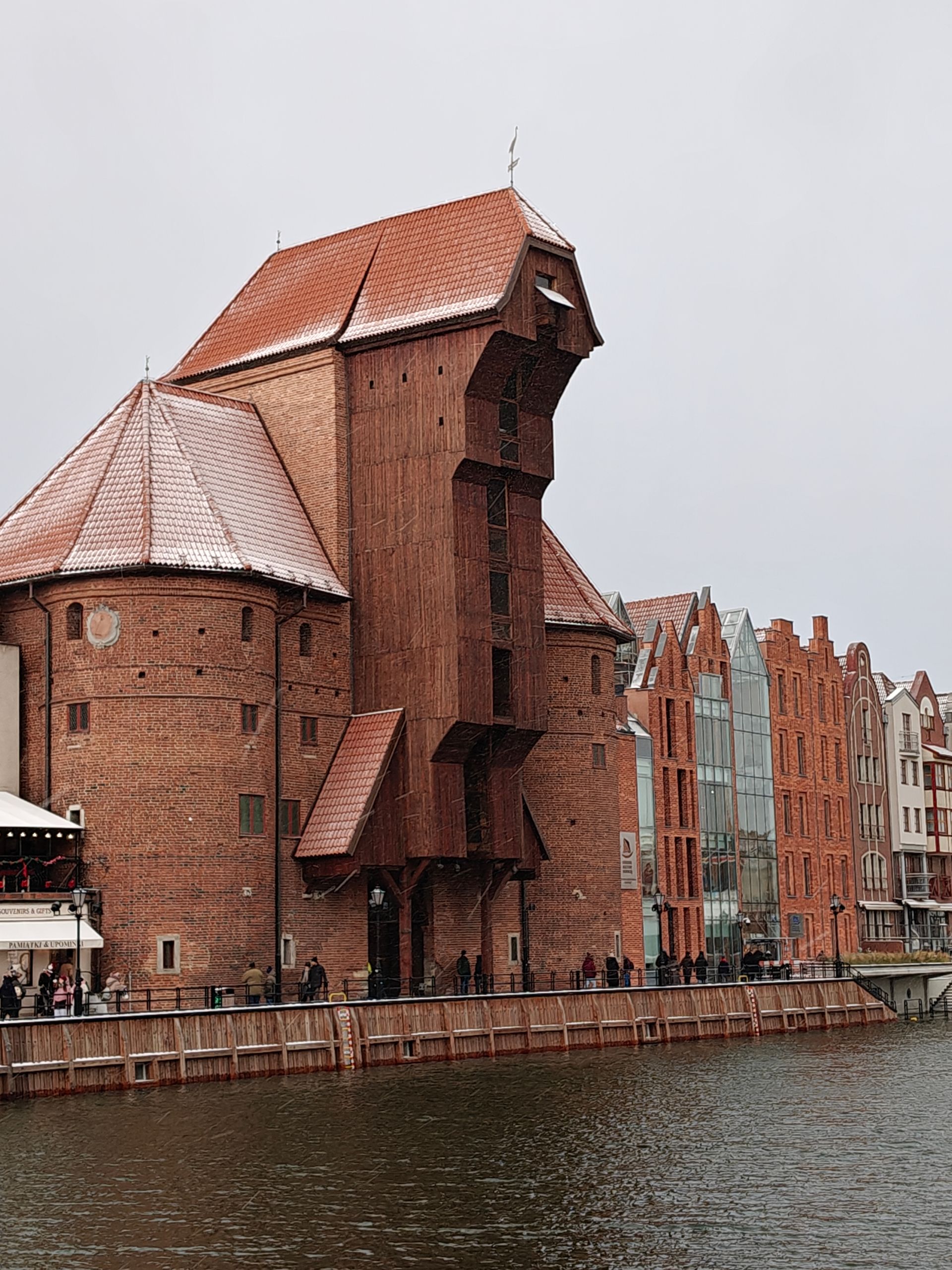 Een bakstenen kraan wordt gebouwd aan het water, terwijl het sneeuwt. Gdańsk, Polen.