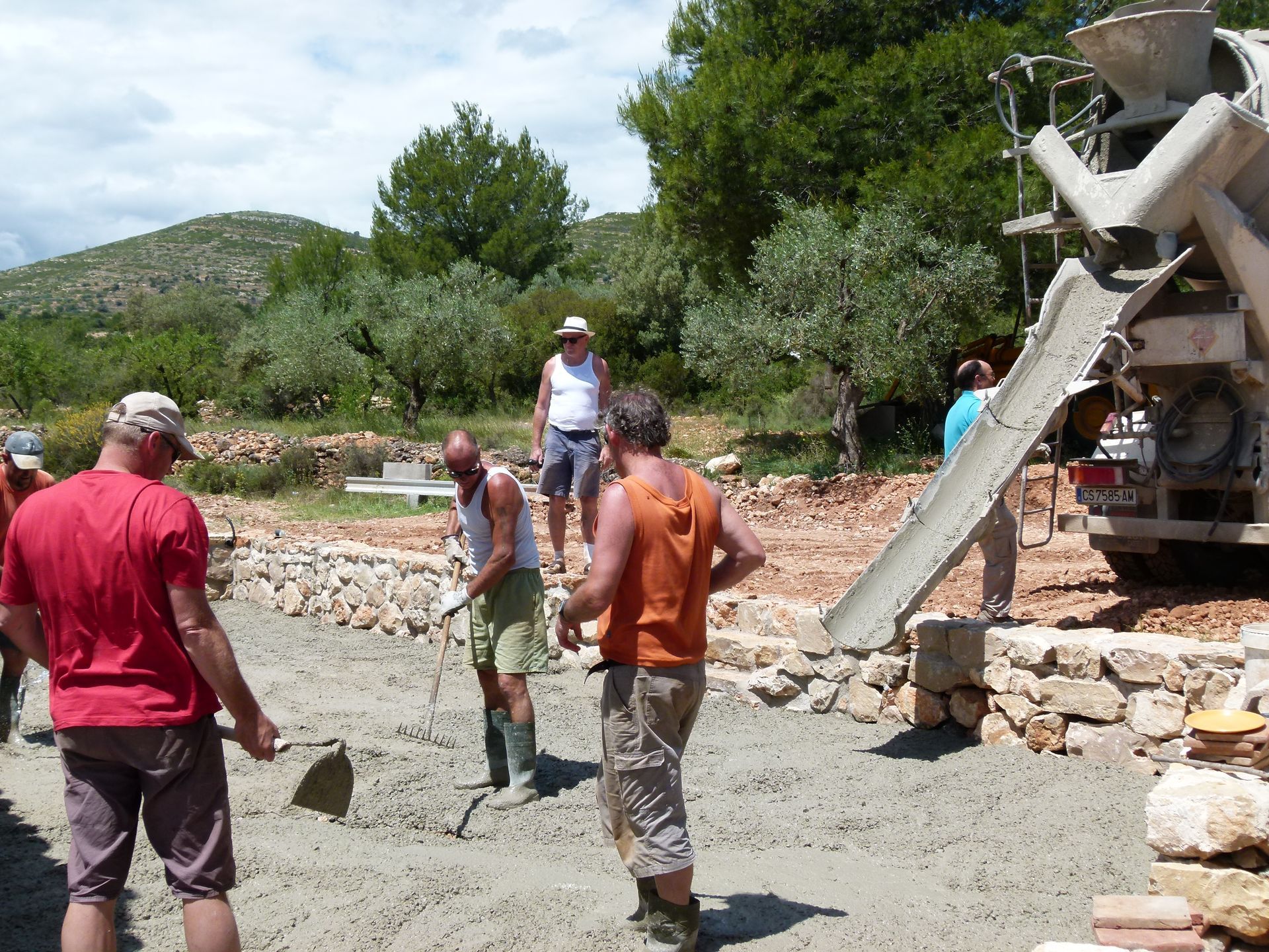 Mensen die beton uit een betonmixer storten op een bouwplaats.