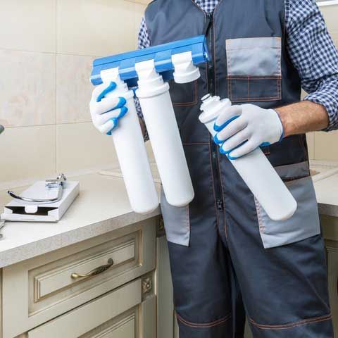 Plumber installing or repairing system of water filtration
