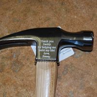 A hammer with a wooden handle is sitting on a table.