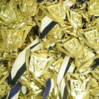 A pile of gold trophies with blue and white ribbons.