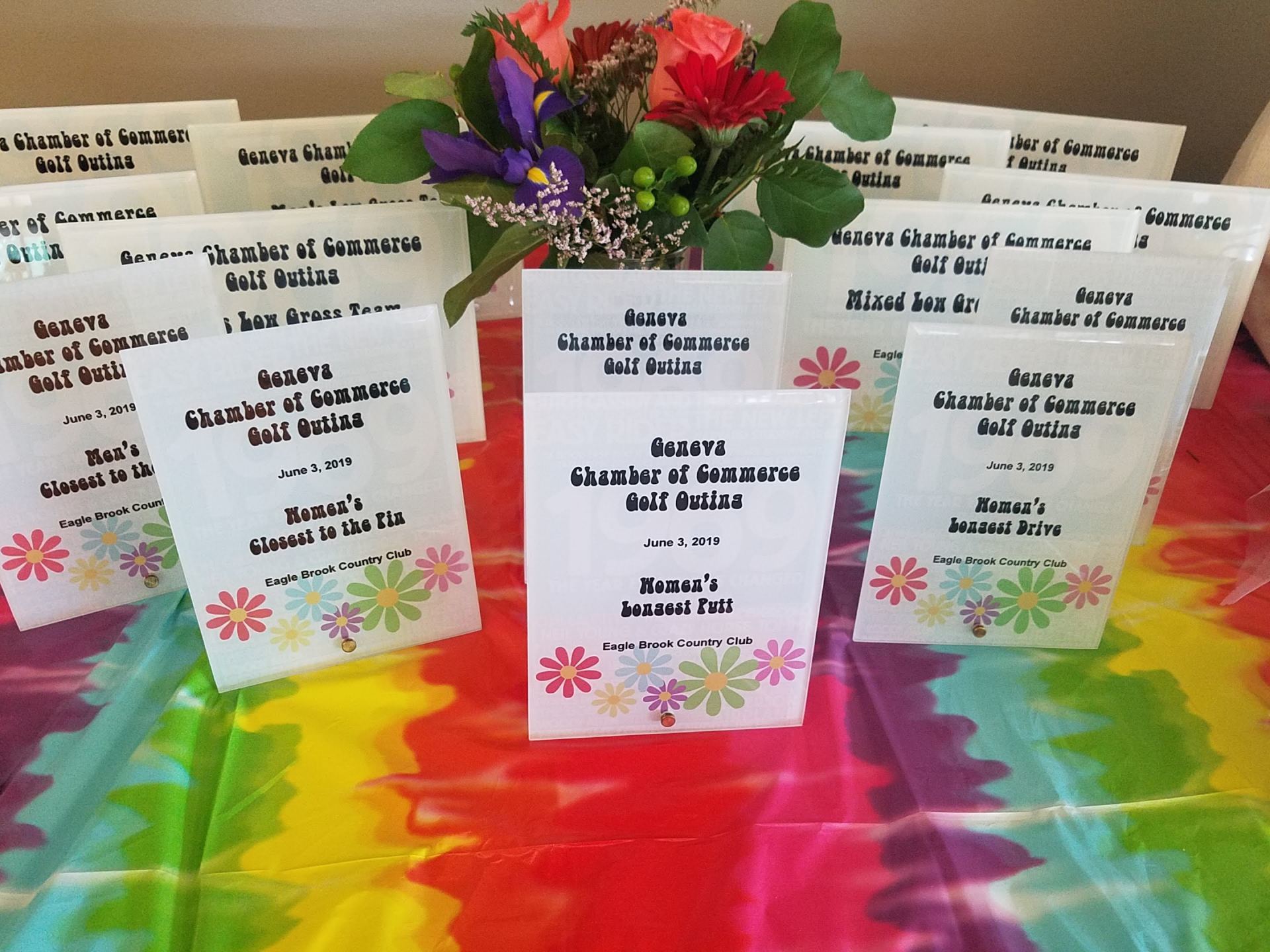 A bunch of place cards on a table with flowers in the background