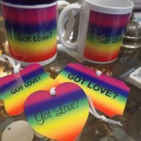 A couple of mugs and a heart with the words `` got love '' on them are sitting on a table.