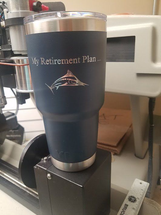 A blue tumbler with the words `` my retirement plan '' on it is sitting on top of a machine.
