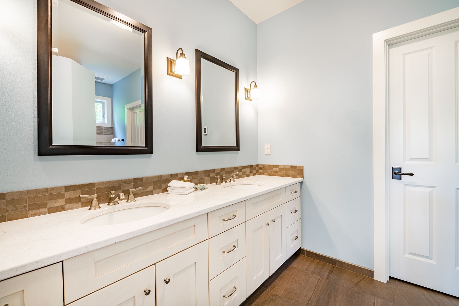 A bathroom with two sinks and two mirrors