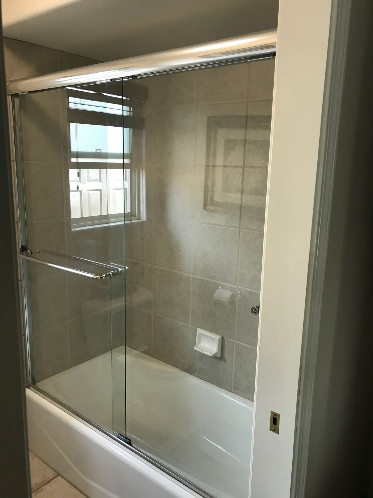 A bathroom with a bathtub and a sliding glass shower door