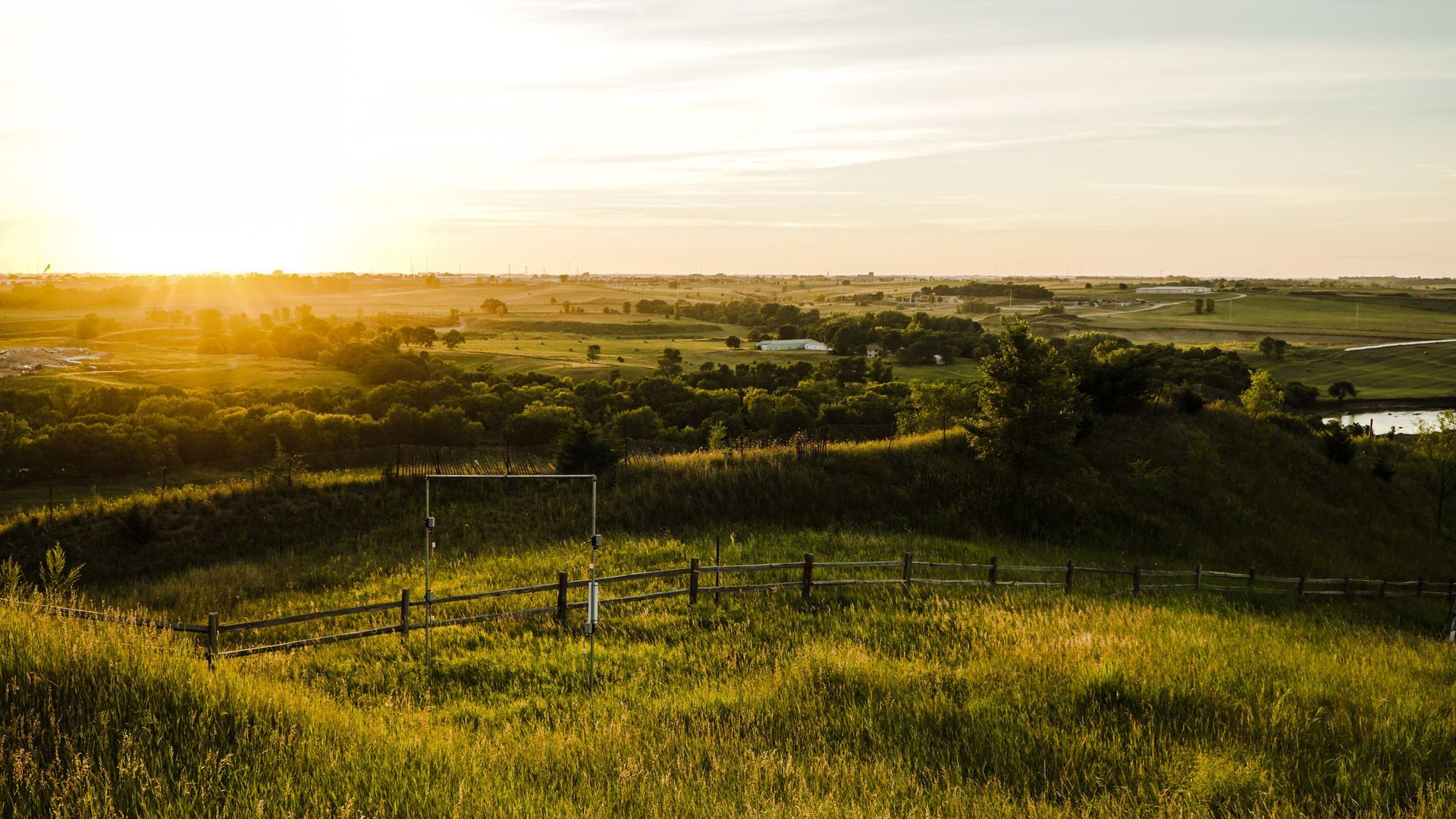 Low-rise building with a flat roof and brick facade. Brown and beige color scheme. Entryway has steps. Clear sky.