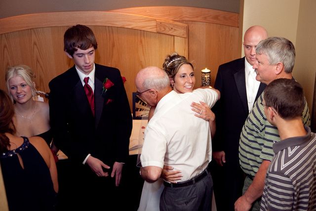 A group of people are standing around a bride and groom