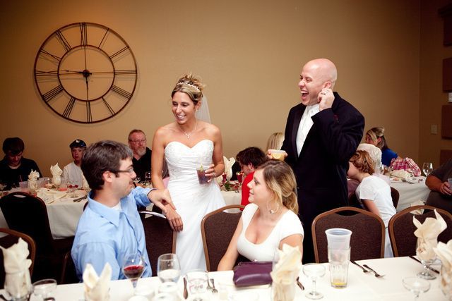 A bride and groom are standing next to each other at a wedding reception.