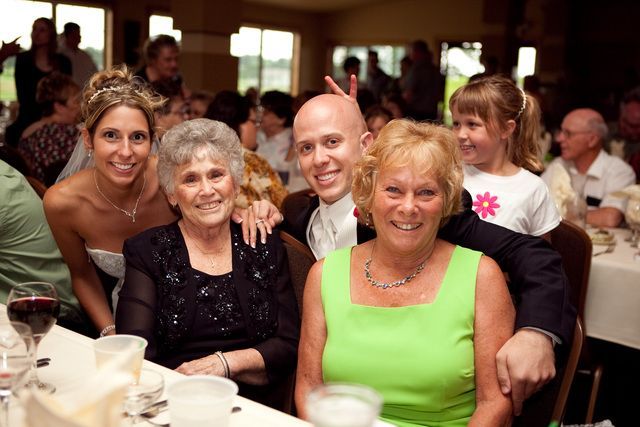 A group of people posing for a picture at a wedding reception