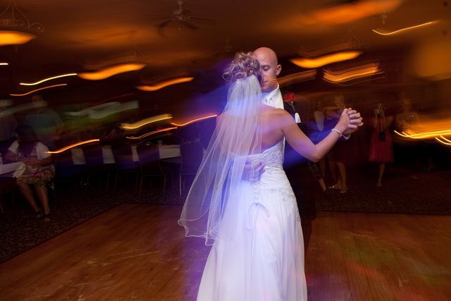 A bride and groom are dancing their first dance at their wedding reception.