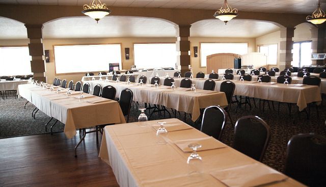 A large room with tables and chairs set up for a meeting