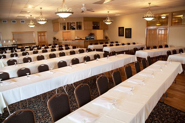 A large room with tables and chairs set up for a conference.