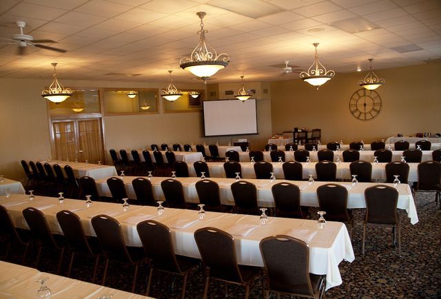 A large room with tables and chairs and a clock on the wall