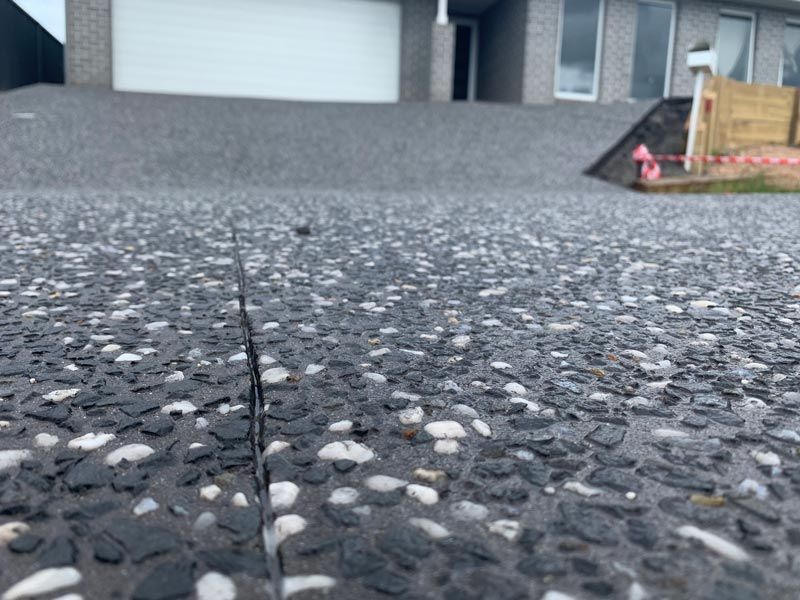 Close Up Pebble Driveway With Garage Door — Brodie Wynter Concreting in Port Macquarie, NSW