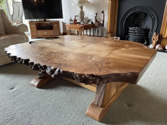 A book-matched burr elm live edge coffee table with a solid elm leg frame.