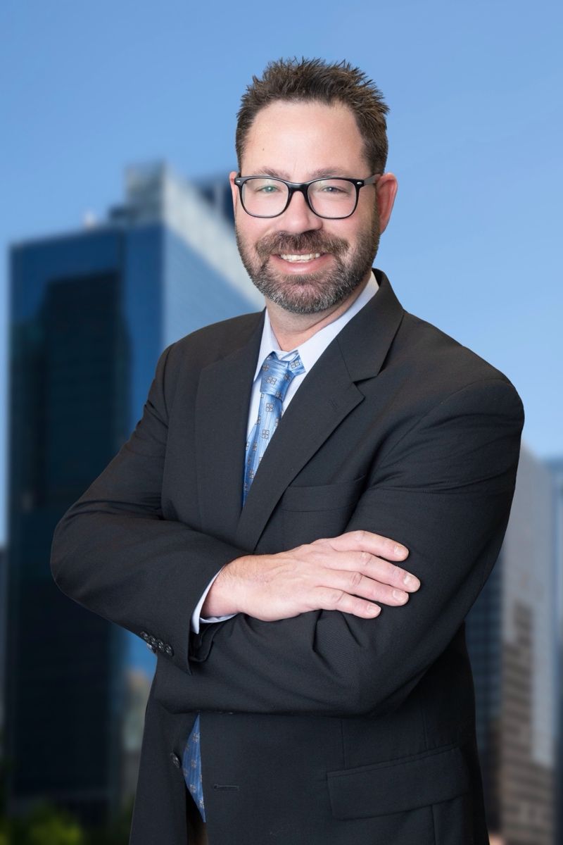 A man in a suit and tie is smiling for the camera