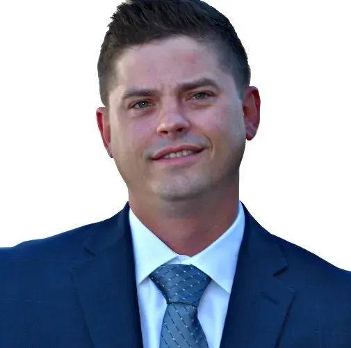 A man in a suit and tie is smiling for the camera