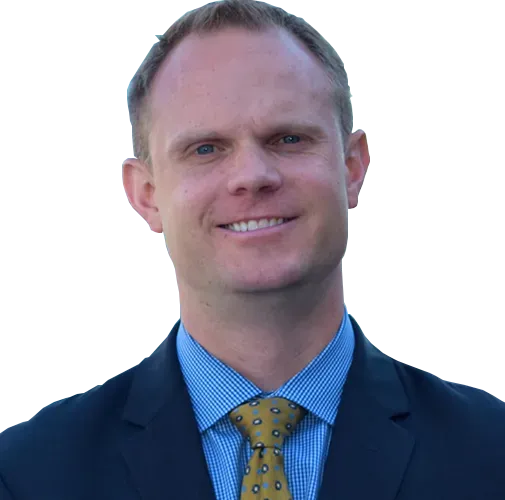 A man in a suit and tie is smiling for the camera