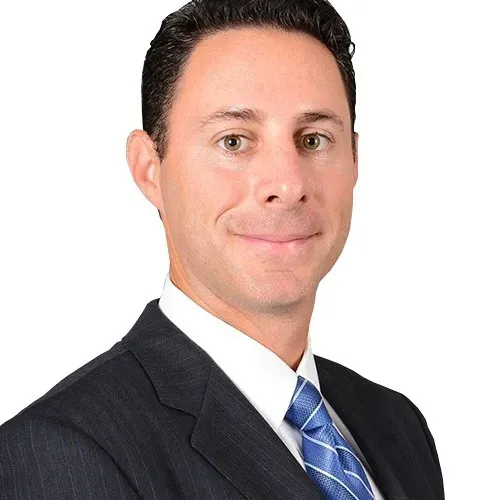 A man in a suit and tie is smiling for the camera