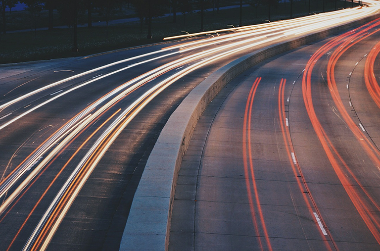 A long exposure photo of a highway with a lot of lights on it.