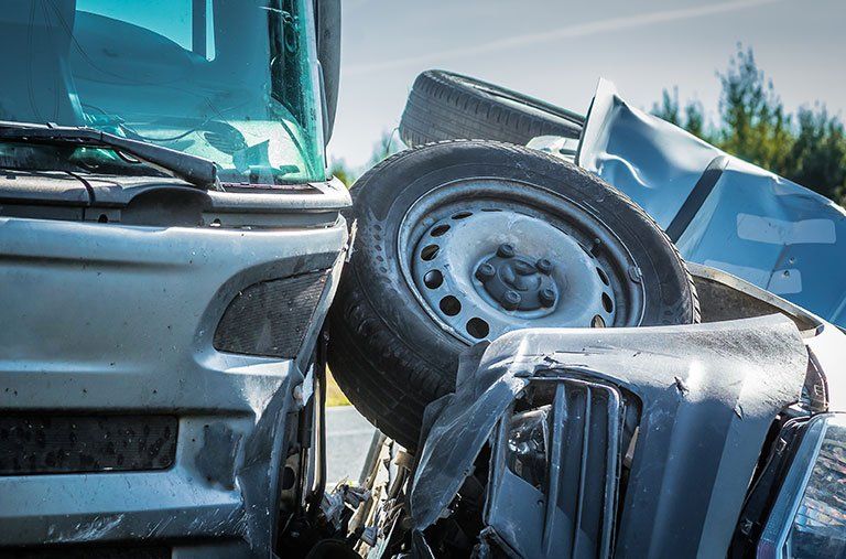 A truck and a car are involved in a collision on the road.