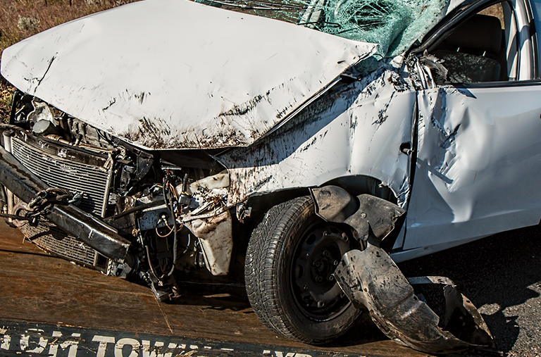 A white car has been damaged in a car accident.
