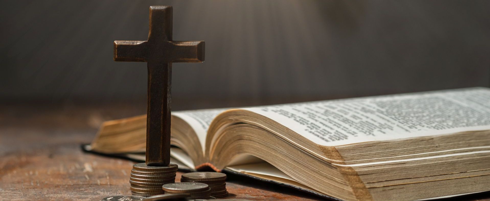 a cross, the bible and some money showing faith with financial health