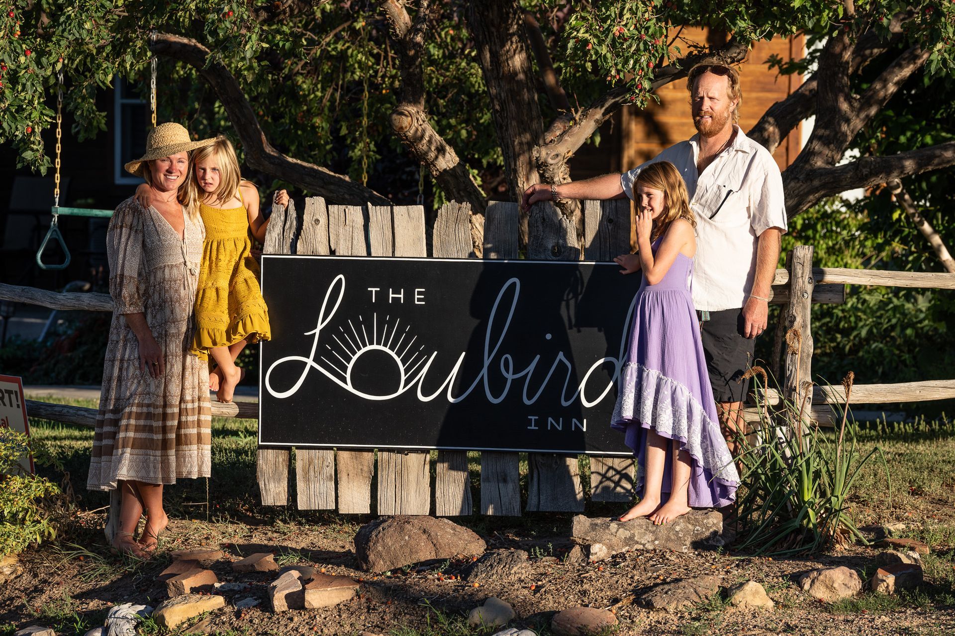 A family standing in front of a sign that says loubird inn