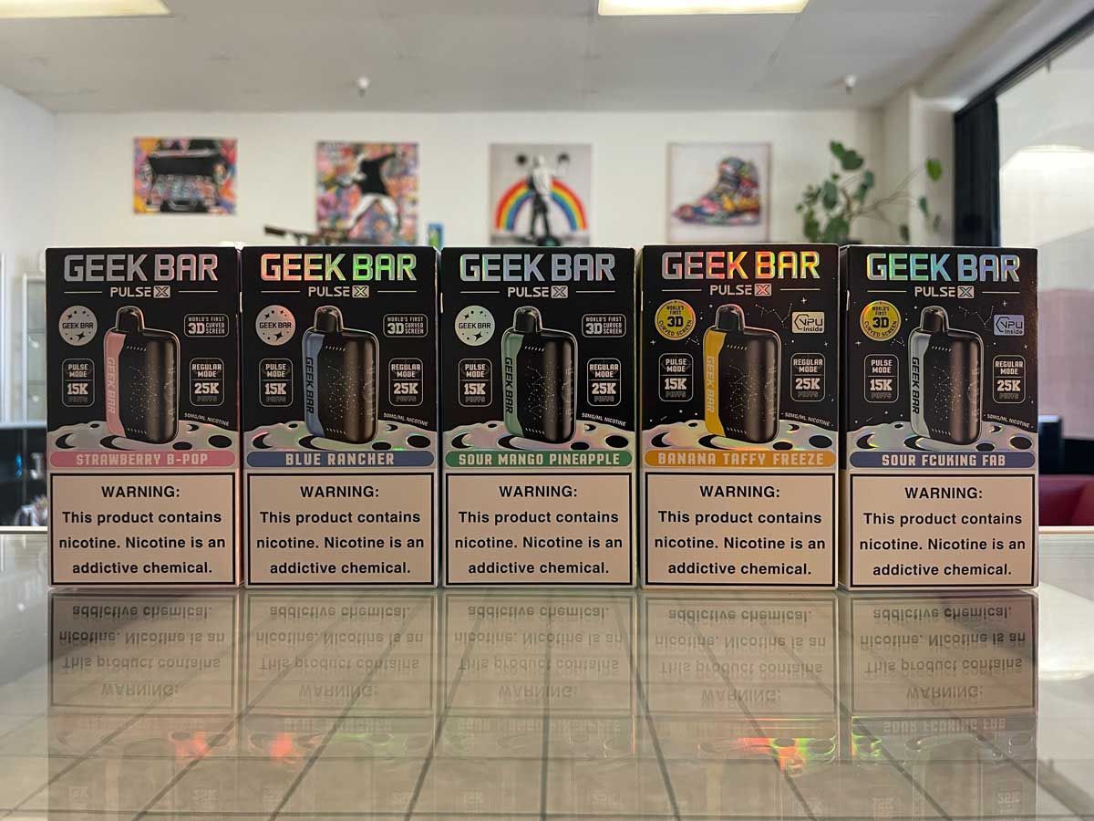 A row of geek bar boxes are lined up on a counter.